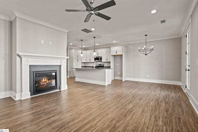 unfurnished living room with hardwood / wood-style floors, crown molding, and ceiling fan with notable chandelier