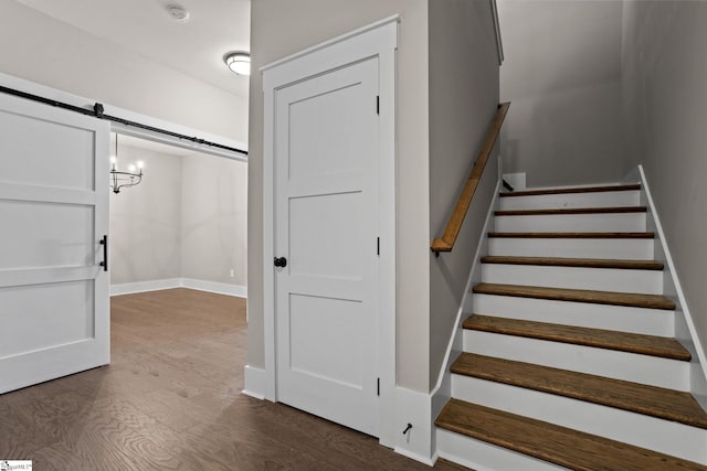 stairs with a barn door and wood-type flooring