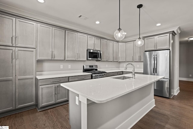 kitchen featuring dark wood-type flooring, pendant lighting, gray cabinetry, appliances with stainless steel finishes, and sink