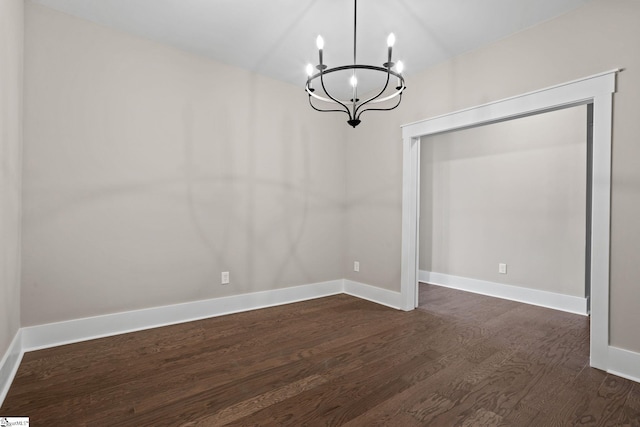 unfurnished dining area featuring dark wood-type flooring and a chandelier