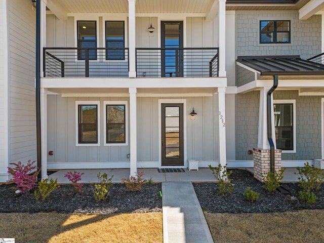 view of exterior entry featuring a balcony