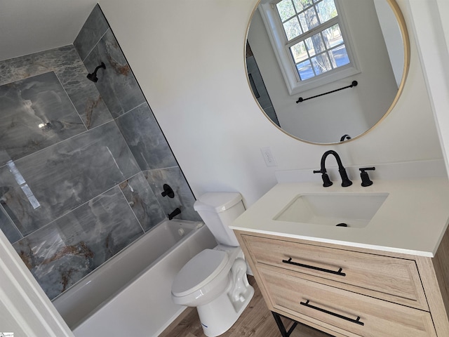 full bathroom with wood-type flooring, vanity, tiled shower / bath, and toilet