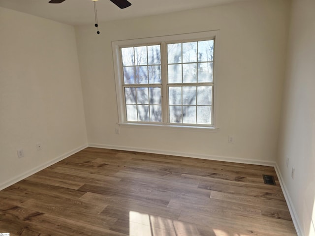 spare room featuring ceiling fan and dark wood-type flooring