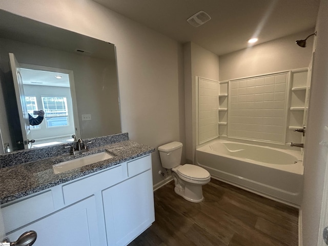 full bathroom featuring toilet, hardwood / wood-style flooring, washtub / shower combination, and vanity