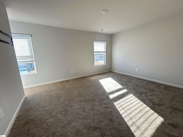 spare room with dark carpet