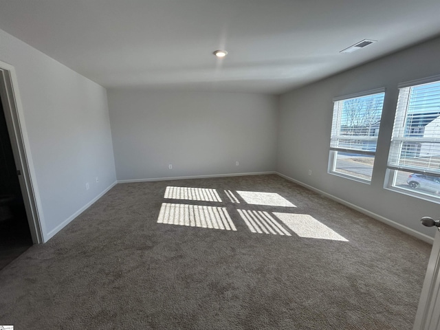 spare room with dark colored carpet