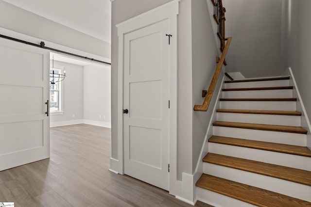 stairs featuring hardwood / wood-style floors and a barn door