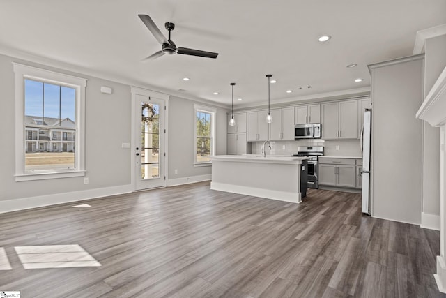 unfurnished living room featuring ceiling fan, sink, and dark hardwood / wood-style floors