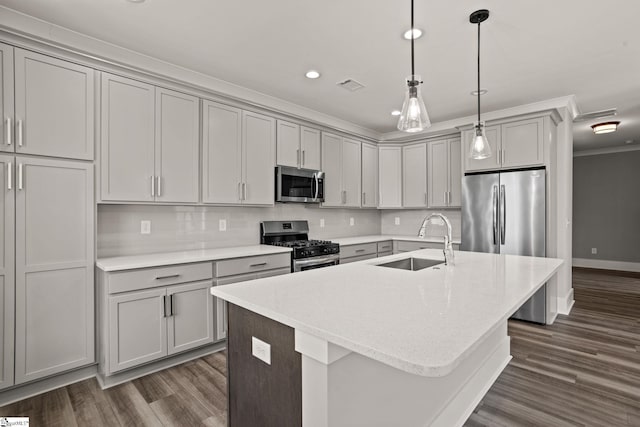 kitchen featuring sink, stainless steel appliances, a kitchen island with sink, and crown molding