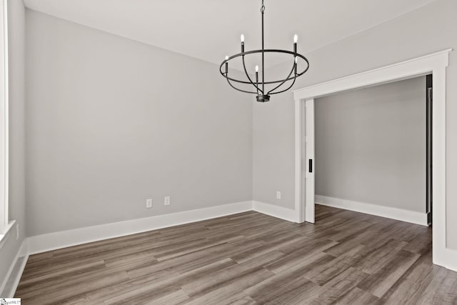 unfurnished dining area with hardwood / wood-style flooring and a notable chandelier