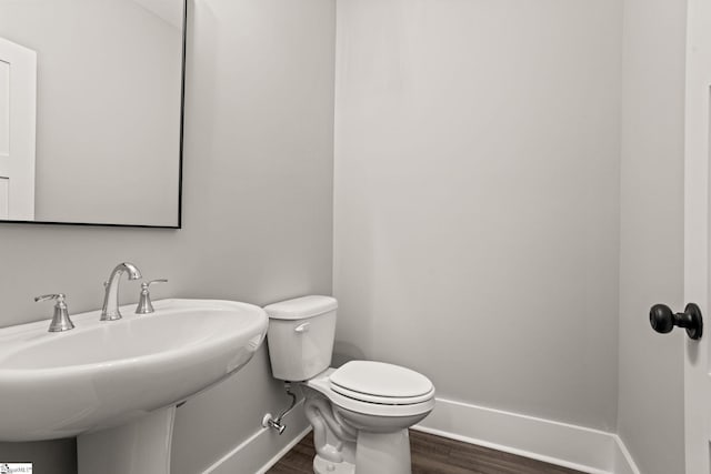 bathroom with sink, toilet, and hardwood / wood-style floors