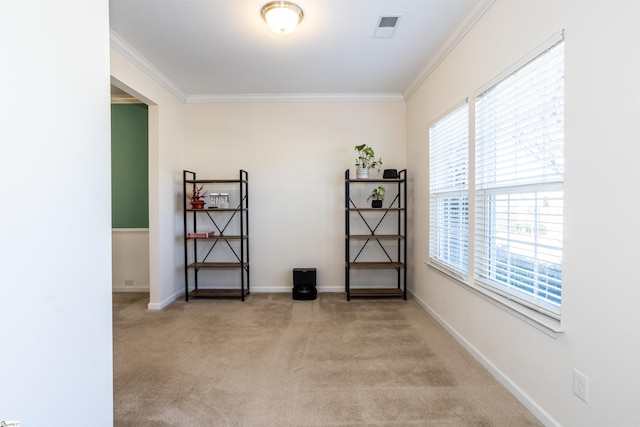 empty room featuring ornamental molding and light colored carpet