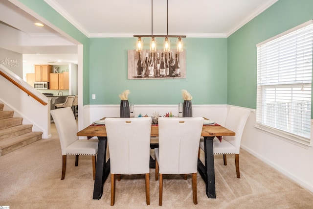 carpeted dining space with ornamental molding