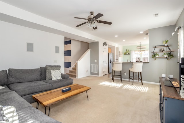 carpeted living room featuring ceiling fan