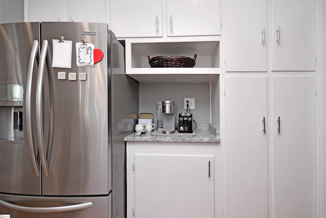 kitchen featuring white cabinetry and stainless steel refrigerator with ice dispenser