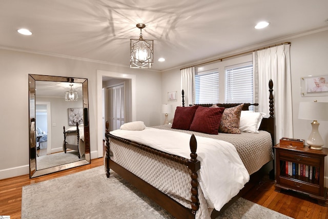 bedroom with ornamental molding, hardwood / wood-style floors, a closet, and a chandelier