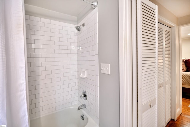 bathroom with wood-type flooring and shower / bath combo with shower curtain