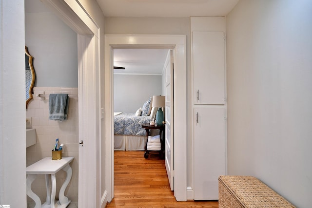 hall featuring tile walls and light hardwood / wood-style floors