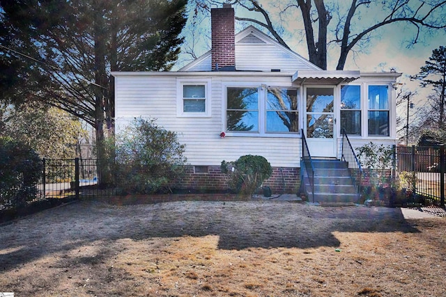 back house at dusk featuring a sunroom