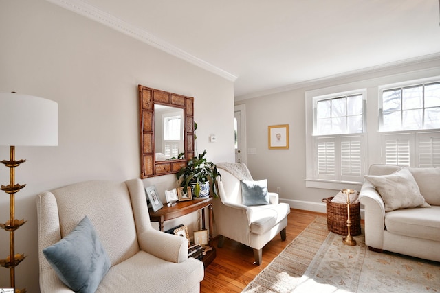 sitting room with ornamental molding and hardwood / wood-style floors