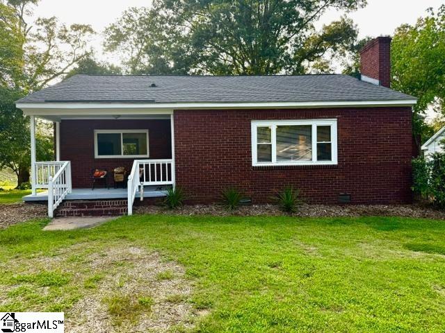 view of front of home featuring covered porch and a front lawn