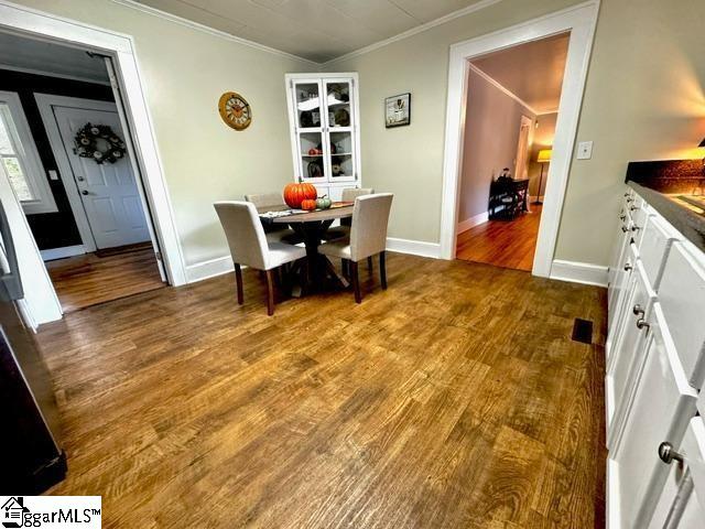 dining area with crown molding and wood-type flooring