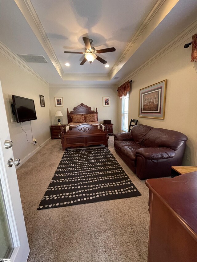 carpeted bedroom featuring a raised ceiling, ceiling fan, and ornamental molding