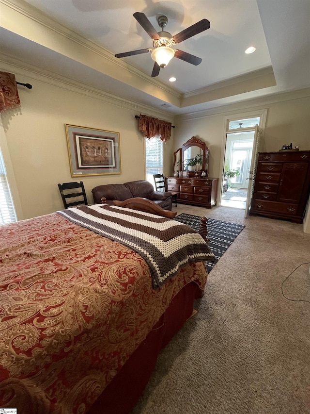 bedroom featuring ornamental molding, ceiling fan, a tray ceiling, and carpet