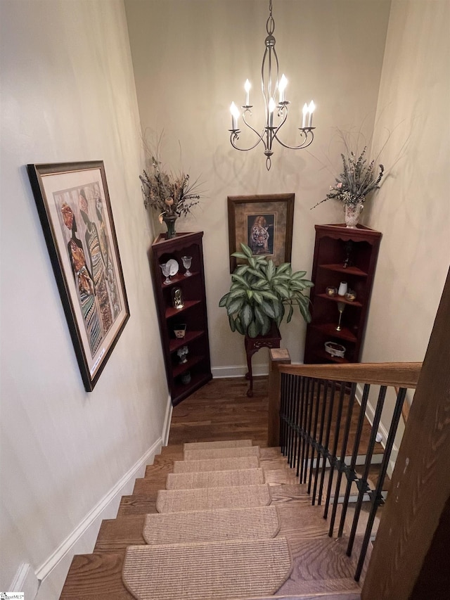 stairway featuring hardwood / wood-style flooring and a chandelier