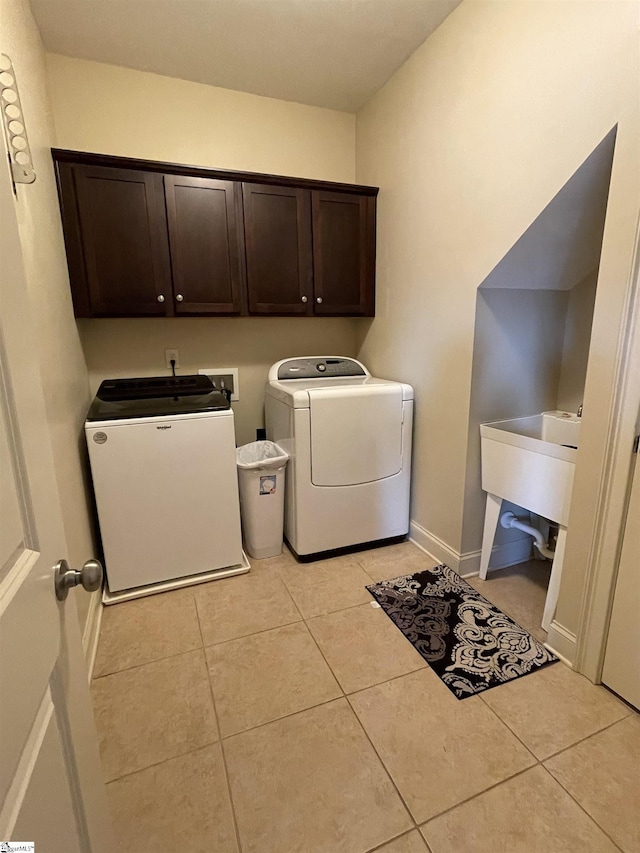 laundry area featuring sink, cabinets, washing machine and dryer, and light tile patterned floors