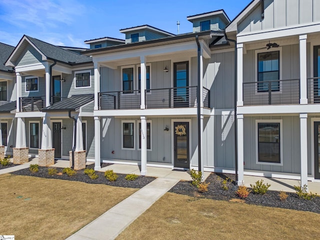 view of front of property with ceiling fan and a front lawn