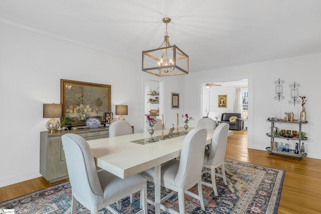 dining room featuring ornamental molding, light hardwood / wood-style flooring, and ceiling fan with notable chandelier