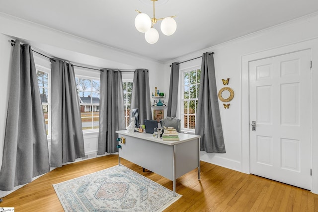 foyer with an inviting chandelier, crown molding, and light hardwood / wood-style flooring