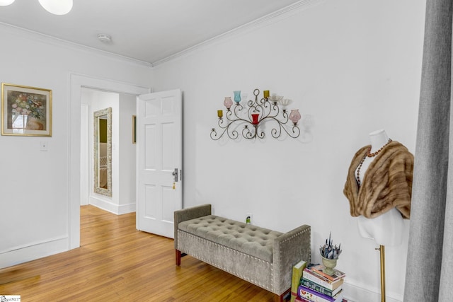 sitting room featuring ornamental molding and wood-type flooring