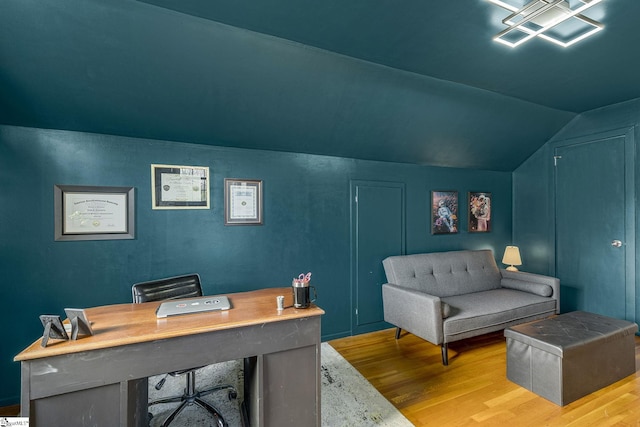 office with light wood-type flooring and vaulted ceiling