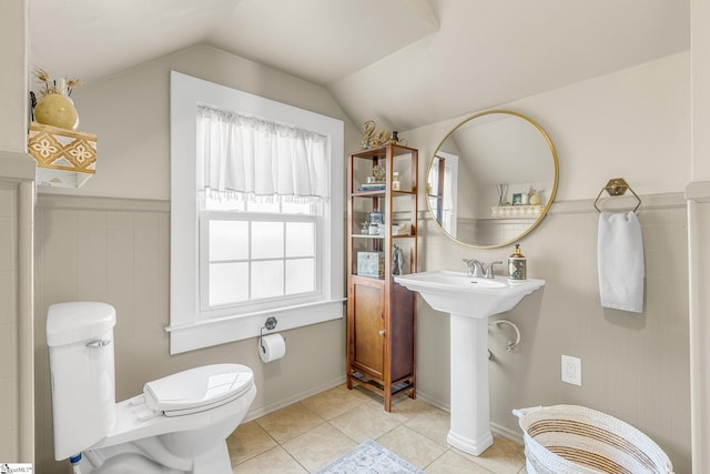 bathroom with lofted ceiling, tile patterned floors, and toilet