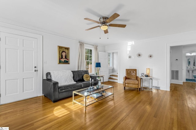 living room featuring hardwood / wood-style floors, ceiling fan, and ornamental molding