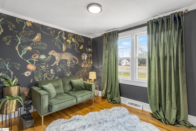 living area with ornamental molding, hardwood / wood-style floors, and plenty of natural light