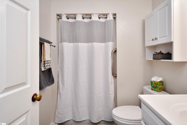 bathroom with curtained shower, vanity, and toilet