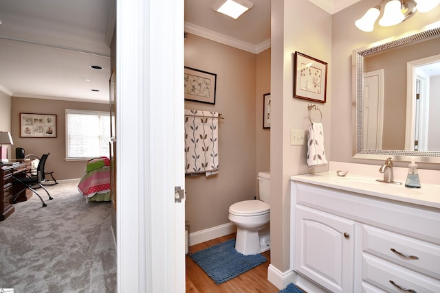 bathroom with ornamental molding, toilet, vanity, and wood-type flooring