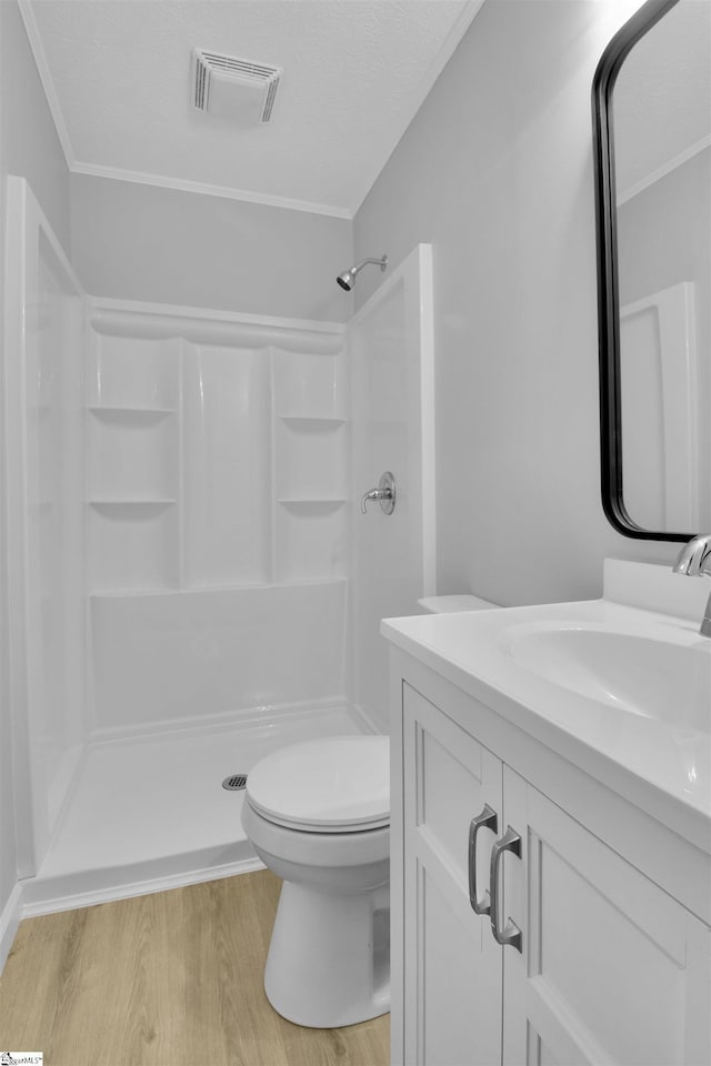 bathroom featuring toilet, a shower, vanity, and hardwood / wood-style floors