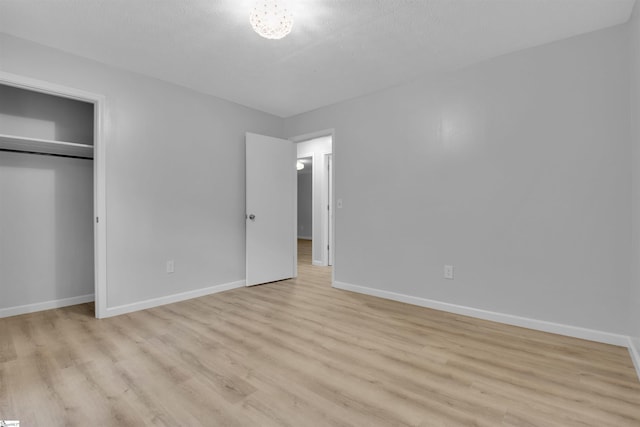 unfurnished bedroom with light hardwood / wood-style floors and a closet