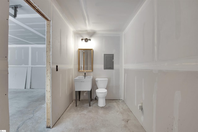 bathroom featuring toilet, concrete floors, and electric panel