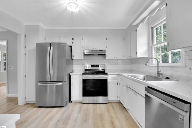 kitchen with appliances with stainless steel finishes, tasteful backsplash, white cabinets, and sink