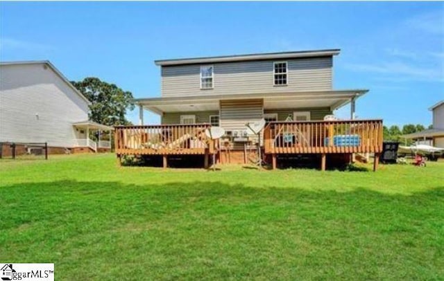 rear view of property featuring a yard and a wooden deck