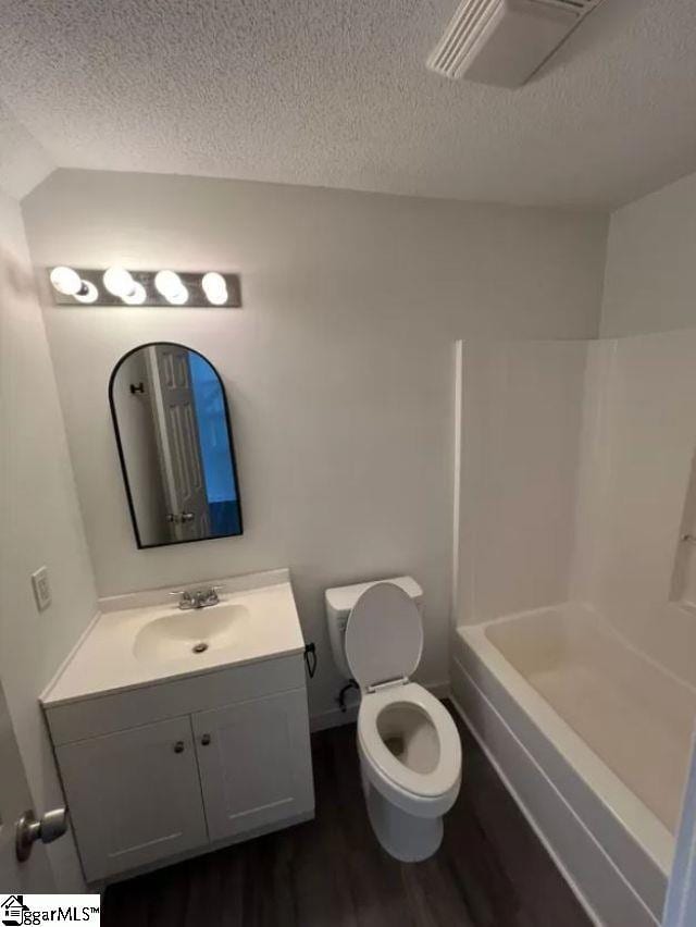 bathroom with a textured ceiling, toilet, vanity, and hardwood / wood-style flooring