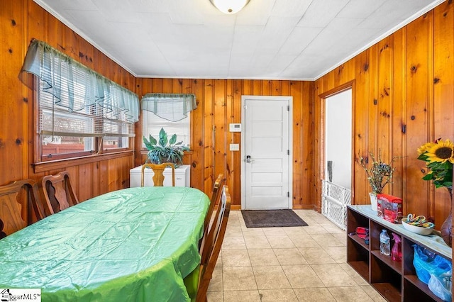 tiled dining area featuring ornamental molding and wooden walls