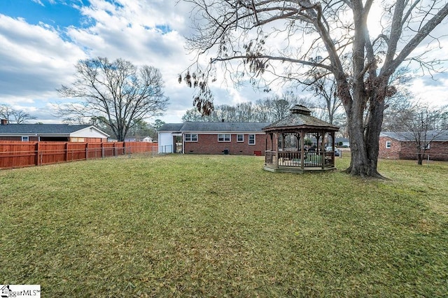 rear view of property featuring a gazebo and a lawn