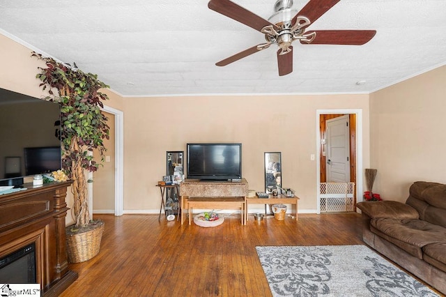 living room with ceiling fan, hardwood / wood-style flooring, and crown molding