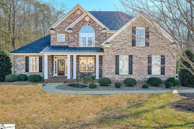 view of front of property with a porch and a front lawn